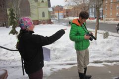 Two students working with a camera in the snow